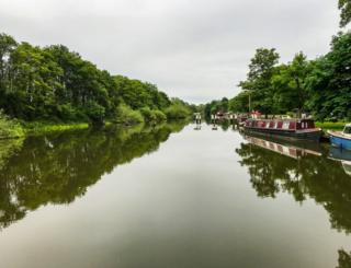 Canal boats reflected in a canal