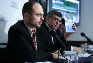 Vladimir Kara-Murza (left) holds up a copy of the report on 'Winter Olympics in the Sub-Tropics' with Russian opposition leader and former Deputy Prime Minister Boris Nemtsov
