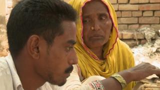 Safia Bibi feeds her mentally ill son rice