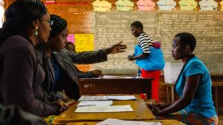 A prospective voter checks her voter registration details with ZEC officials on May 29 2018 at an inspection centre in Harare, ahead of Zimbabwe harmonised 2018 general election, expected for July.