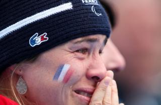 A French coach cries as she watches the medal ceremony of the Alpine Skiing Women's Slalom