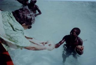 TN Pandit regalando un coco a un hombre sentinelés.