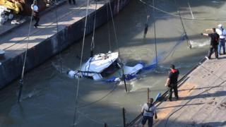 Rescue workers and crew members are helped by a giant floating crane, the Clark Adam ship, to lift the sunken sightseeing boat Mermaid in Budapest on June 11, 2019
