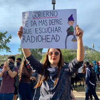 Una mujer sostiene un cartel