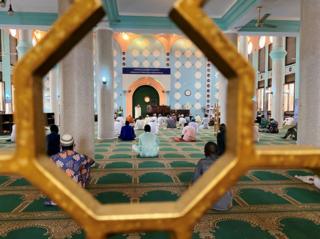 Worshippers sit inside and pray.