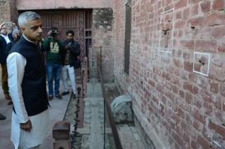 Мэр Лондона Садик Хан смотрит на следы от пуль на стене во время своего визита в Джаллианвала Багх в Амритсаре