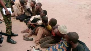 Awọn afunrasi ti ọwọ ba joko lori ilẹ niwaju ologun