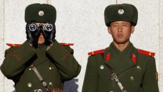 Северокорейские солдаты смотрят на Южную Корею через Корейскую Демилитаризованную Зону (ДМЗ) 22 декабря 2011 года в Панмунжоме, Южная Корея.