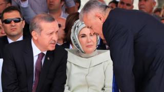 Turkish Prime Minister Recep Tayyip Erdogan (L), flanked by his wife Emine, talks with Turkish Transport Minister Binali Yildirim at event in 2013