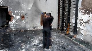 Two girls hug while they stand at the destroyed school gym in Beslan, North Ossetia, 05 September 2004