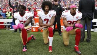 Colin Kaepernick (centro) y dos jugadores de los San Francisco 49ers se arrodillan durante el Himno Nacional de Nueva York. Foto: octubre de 2016