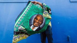 Un militant du parti au pouvoir exhibe un tissu avec la photo du président Ramaphosa.