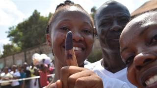 A women shows her finger after voting for the general elections, on March 7, 2018 at a polling station in Freetown. More than 3.1 million voters are registered for the polls across the small West African nation