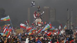 in_pictures Protesters shout slogans and wave flags of Chile and the Mapuche people during a national strike and general demonstration called by different workers' unions on 12 November, 2019 in Santiago, Chile.