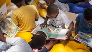 Niños leen en una actividad de la organización Pasa la Cebra.