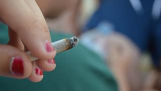 A teenager smokes cannabis