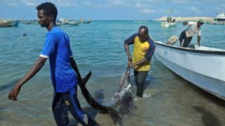 Wasu masunta a Somali na fito da kifin da suka kama daga kwale-kwale a gabar tekun Bosaso da ke yankin Puntland na arewa maso gabashin kasar.