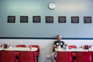 A photo of a man looking thoughtful in a cafe