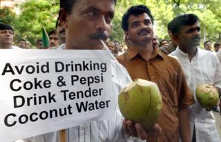 Activists of the Indian federal Democratic Party drink coconut water during a demonstration against against cola giants Pepsi and Coke in New Delhi, 21 August 2003.