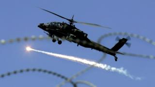 A US military Apache helicopter releases an anti missile decoy flare as it flies over Baghdad, Iraq, Thursday, Feb. 15, 2007.