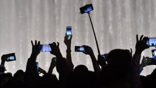 Personas con teléfonos celulares