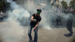Joven en medio de gases lacrimógenos.