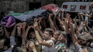 Palestinian mourners carry the body of Razan al-Najar during her funeral in Khan Younis, southern Gaza Strip, 2 June 2018