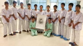 12명의 태국 소년들과 코치는 구조 중 목숨을 잃은 사만 푸난의 초상화와 함께 사진을 찍었다