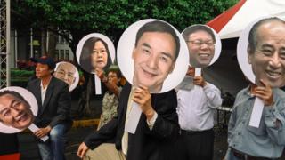 台灣民眾在集會中舉起總統參選人及可能參選者的頭像。