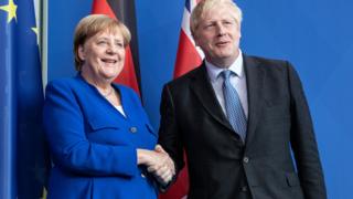 Angela Merkel and Boris Johnson shake hands in Berlin