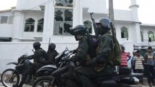 Police ride past the Jumha Mosque