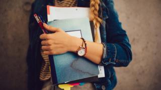 Student holding folders