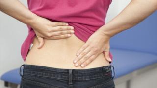 A woman rubbing her back