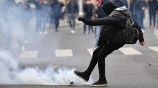 A protester kicks a tear gas canister during the demonstration in Paris (23 February 2017)