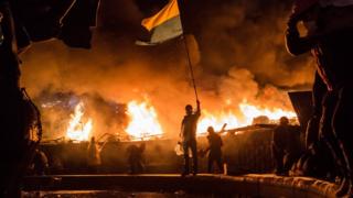 Майдан, палає вогонь, демонстрант із українським прапором