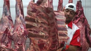 Carnes colgando en un frigorífico.