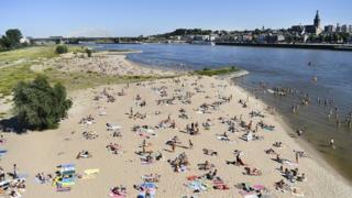 Die Menschen genießen das warme Wetter im Fluss Waal in Nijmegen, Niederlande