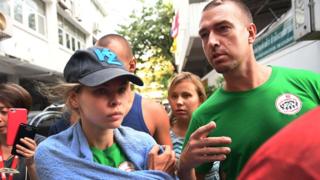 A modelo bielorrussa Anastasia Vashukevich, (à esquerda) conhecida por seu pseudônimo Nastya Rybka com o "guru da sedução" russo Alex Kirillov (à direita) deixa o departamento de imigração tailandês em Bangkok em 17 de janeiro de 2019