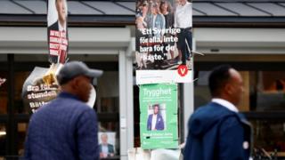 People pass election campaign posters in Stockholm on September 7