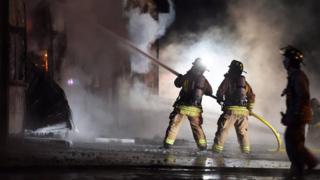 Firefighters spray water on a building