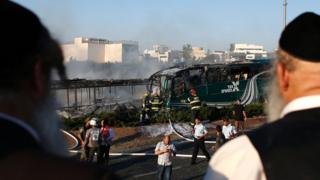 Еврейские мужчины осматривают место взрыва автобуса в Иерусалиме 18 апреля 2016 года.