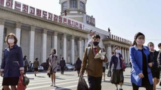 Люди носят маски перед станцией Пхеньян в Пхеньяне, Северная Корея (27 апреля 2020 г.)