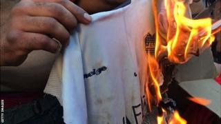 A River Plate fan sets a Boca Juniors shirt alight