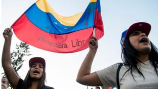 Venezuelan citizens living in Chile shout slogans during a demonstration against president Nicolas Maduro"s government in Santiago, Chile, on April 30, 2019
