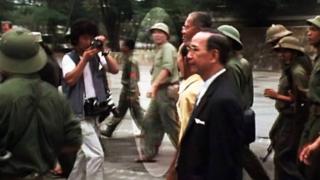 Political Commissar Tung and Mr. Duong Van Minh on the way from the Independence Palace to two jeeps to the radio station