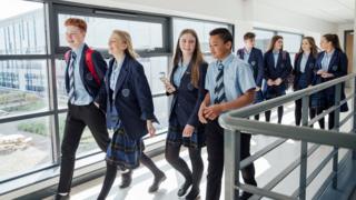 Teenagers walking in school corridor