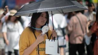 Женщина держит веер в Японии