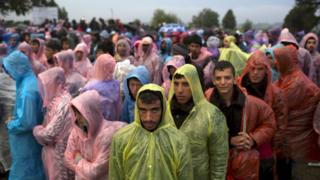 Migrants stand on a field, after they crossed the border with Serbia, near Tovarnik, Croatia