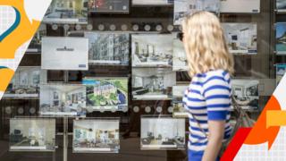 Woman looking inside an estate agent's window