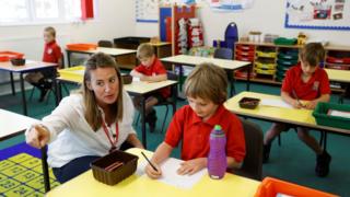 A teacher talks to a child at Watlington Primary School as some schools re-open, following the outbreak of the coronavirus disease (COVID-19), Watlington